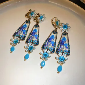 Detailed view of vintage resin flower drop earrings featuring elegant blue rhinestones