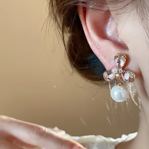 Close-up detail of vintage floral pearl earring with pink crystals and gold plating