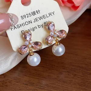 Close-up of retro French 18k gold plated flower stud earrings with pink crystals and pearls