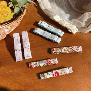 Close-up of various Korean floral fabric bow hair clips displayed on a wooden surface