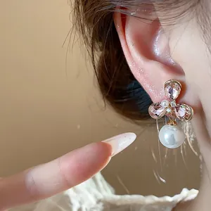 Close-up of vintage French flower earrings with pink crystal and pearl