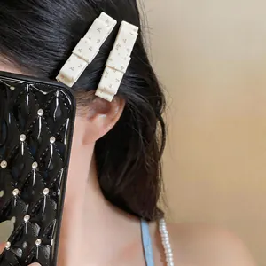 Close-up detail of elegant cream floral fabric bow hair clips worn on black hair