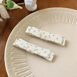 Close-up of elegant floral print fabric bow hair clips on a ceramic plate