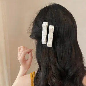 Detailed view of Korean style floral fabric bow duckbill hair clip on wavy hair