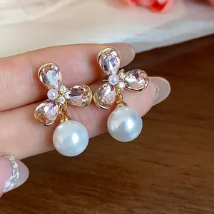 Close-up detail of elegant 18k gold plated flower earrings with pink crystals and pearls