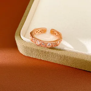 Detail shot of a rose gold ring with geometric triangular facets and inlaid zircon stones