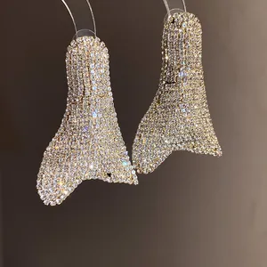 Dettaglio di orecchini geometrici oversize con strass luccicanti
