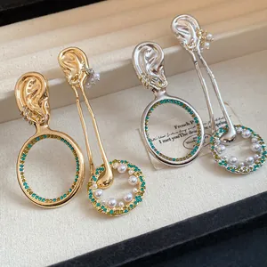 Primo piano di orecchini pendenti vintage in oro e argento con cristalli e perle