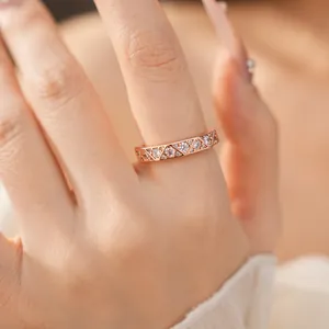 Detail of a rose gold geometric triangle ring inlaid with brilliant cubic zirconia on hand