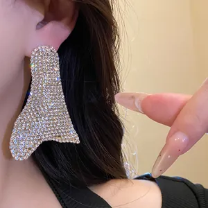Primo piano dettagliato di orecchini geometrici con strass dal finish scintillante.
