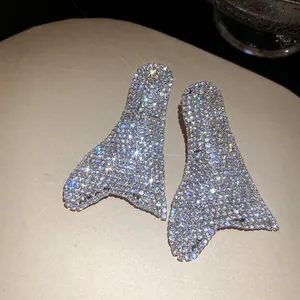Primo piano dettagliato di orecchini geometrici scintillanti impreziositi da strass.