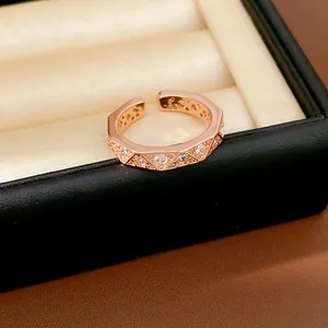 Close-up of rose gold open ring with geometric triangle facets and zircon inlays