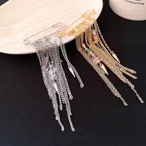 Vintage safety pin brooch featuring long chain tassels and natural crystal stones for women.