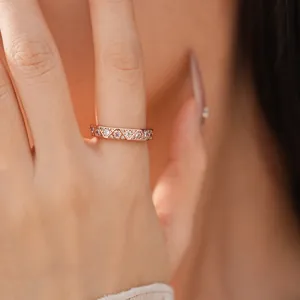 Close-up of rose gold geometric ring with triangular patterns and sparkling zircons