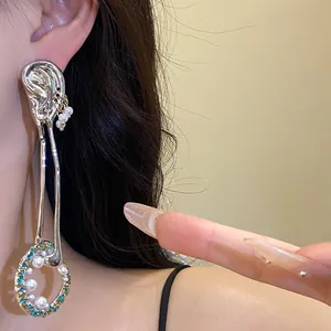 Dettaglio di orecchini pendenti vintage in argento con cristalli blu e perle