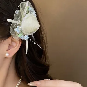 Elegante fermaglio per capelli con rosa in tulle crema, fiori blu e perle