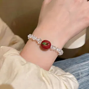 Elegant clear faceted beaded bracelet featuring a cute red resin apple pendant charm