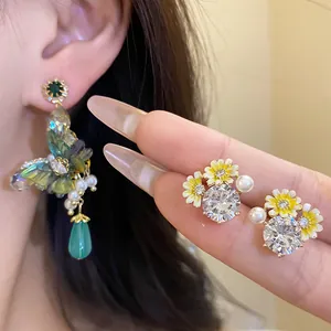 Close-up detail of forest-style flower and butterfly earrings with zircon and pearls