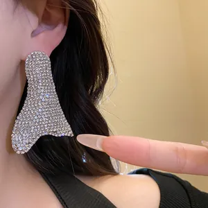 Primo piano di orecchino geometrico irregolare con strass scintillanti