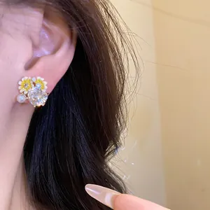 Close-up of elegant flower stud earring with shimmering zircon and pearl detail