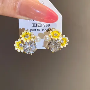 Detailed macro view of elegant silver earrings featuring sunflowers zircons and white pearls