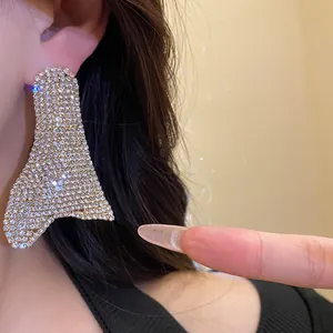 Dettaglio di eleganti orecchini geometrici irregolari oversize con strass scintillanti