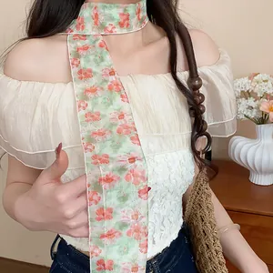 Close-up of a sweet floral skinny scarf worn as a stylish and elegant necklace accessory