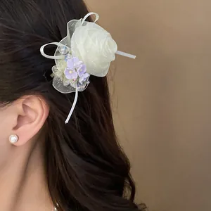 Dettaglio di un'elegante fermaglio per capelli a rosa in garza bianca con fiori e perline