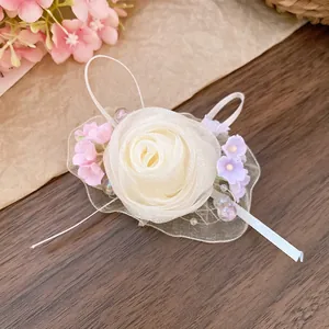 Dettaglio di un grazioso fermaglio per capelli con rosa in rete, perline e fiori