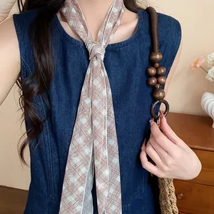 Close-up of a sweet plaid skinny scarf worn as a stylish necklace detail.