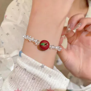 Detailed view of sweet beaded bracelet with a red resin apple pendant on wrist