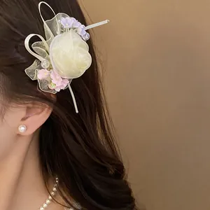 Elegante fermaglio per capelli in rete con rosa e fiori di perline sui capelli di una modella