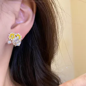Close-up view of elegant daisy stud earrings featuring a large zircon and delicate pearl