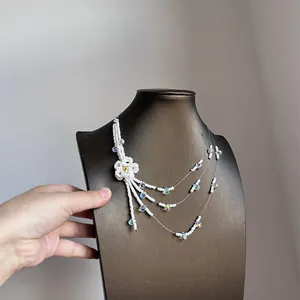 Detailed view of a multi-layer beaded necklace featuring a white flower and crystal beads