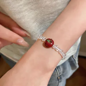 Detailed view of sweet apple charm bracelet with clear faceted beads on wrist