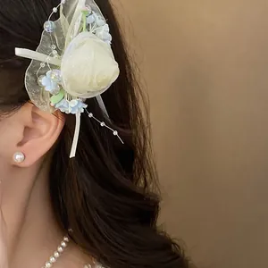 Dettaglio di un'elegante fermaglio per capelli a rosa in rete con perline di perle.