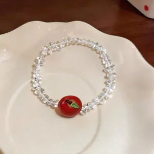 Detailed shot of a sweet beaded resin bracelet with a charming red apple pendant