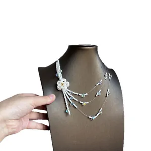 Elegant white floral beaded multi-layer necklace on a jewelry display bust.