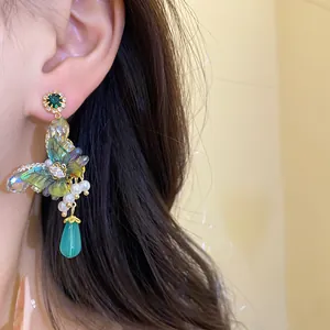 Detailed view of handmade Mori-style butterfly drop earring with green zircon and pearls