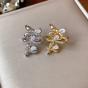 Close-up of elegant 18k gold and silver plated bow ear cuffs with sparkling zircons