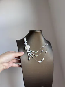 Detailed view of a multi-layer white beaded flower tassel necklace on a display