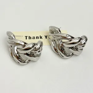 Macro view of polished silver C-shaped chain link earrings with hollow minimalist design