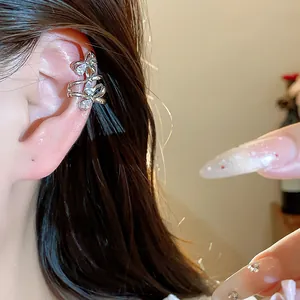 Detailed close-up of a 18k gold plated bow-knot ear cuff with sparkling zircons