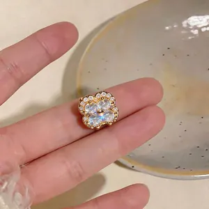 Close-up of elegant 18k gold plated flower ear cuff with sparkling zircon inlay