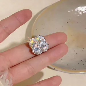 Detailed close-up of the sparkling zircon flower-shaped ear clip in 18k gold plating