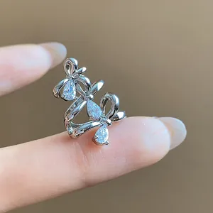 Macro view of bow zircon ear cuff showing 18k gold plating and sparkling teardrop stones