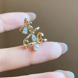 Detailed view of an 18k gold plated bow ear cuff featuring sparkling pear-cut zircons.