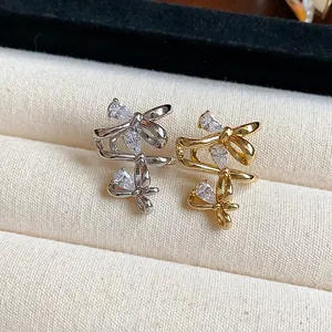 Detailed view of sparkling zircon bow ear cuffs with 18k gold plating in two tones