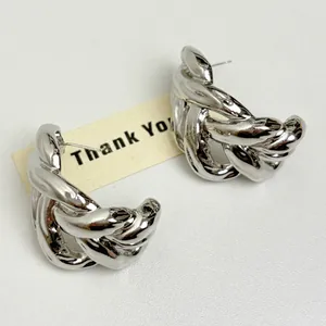 Close-up of silver C-shaped twisted chain earrings with a hollow minimalist design.