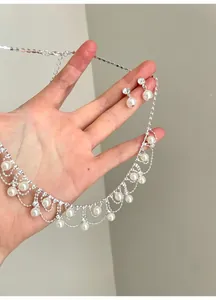 Detailansicht des Vintage-Perlen- und Strass-Halsketten-Ohrring-Sets in der Hand